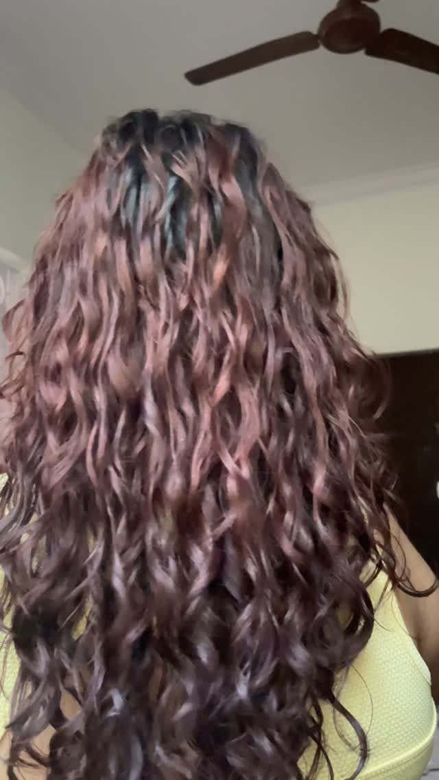 Long wavy reddish-brown damp hair cascading down a person's back