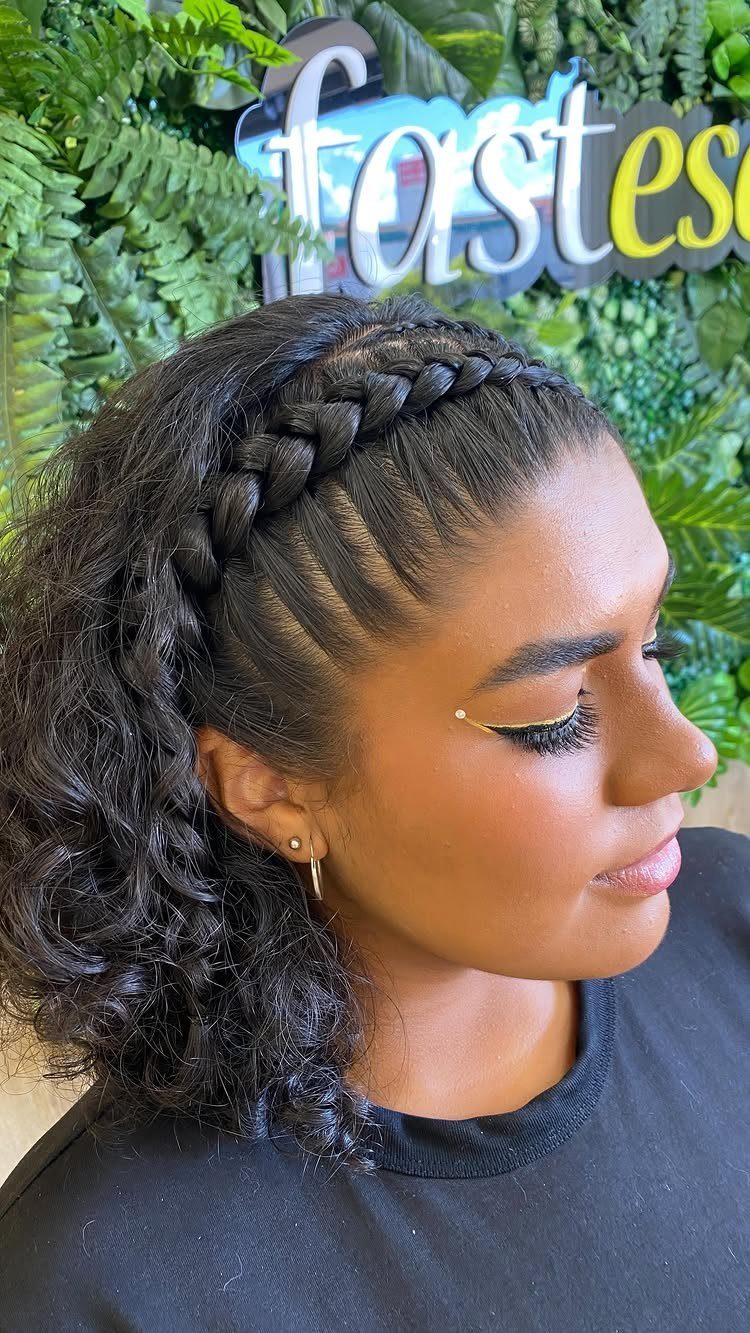 Woman with dark curly hair and a thick braid wrapped around her head.