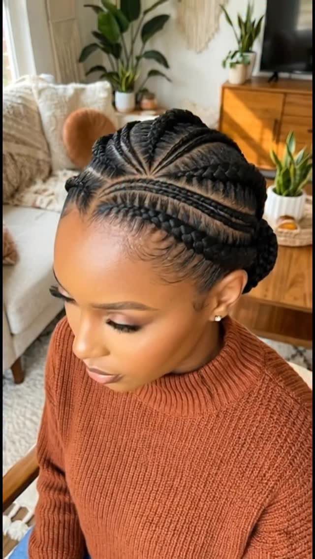 Woman with dark hair styled in cornrow braids wrapped around her head.