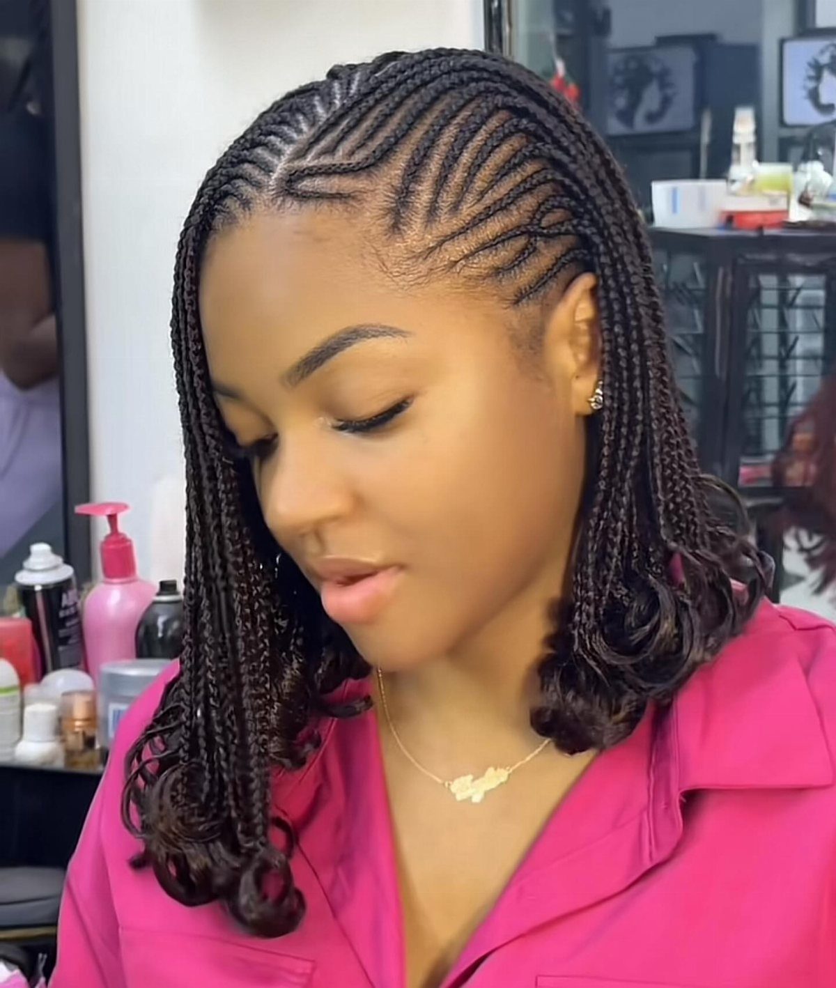 Woman with cornrows curving around her head transitioning into loose hanging braids.