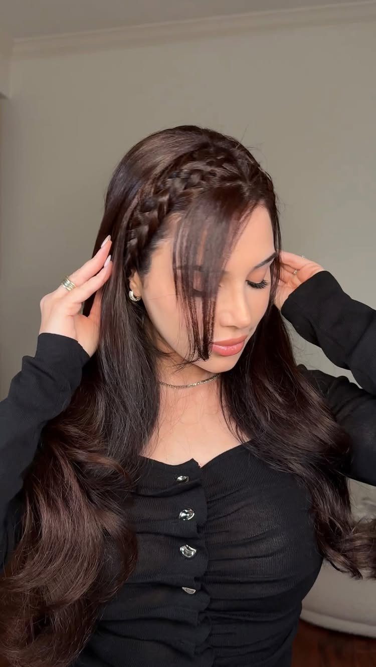 Woman with long dark hair featuring a loose French braid headband hairstyle.