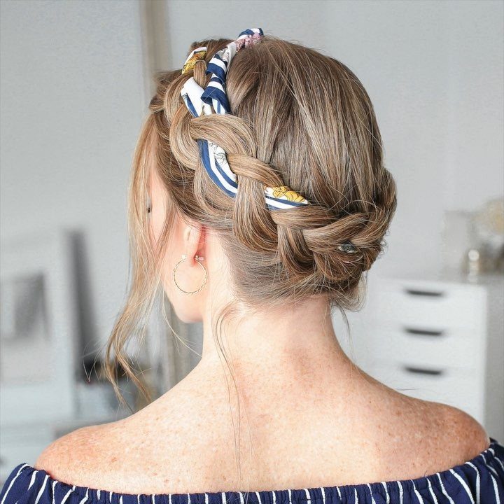 Blonde hair styled in a braid wrapped around the head with a scarf.