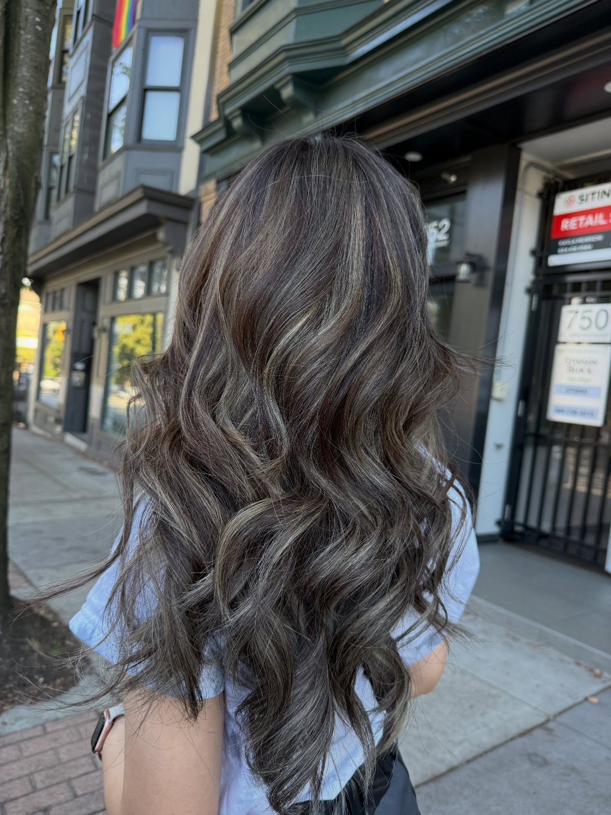 Long wavy dark brown hair with cool ash blonde highlights from behind