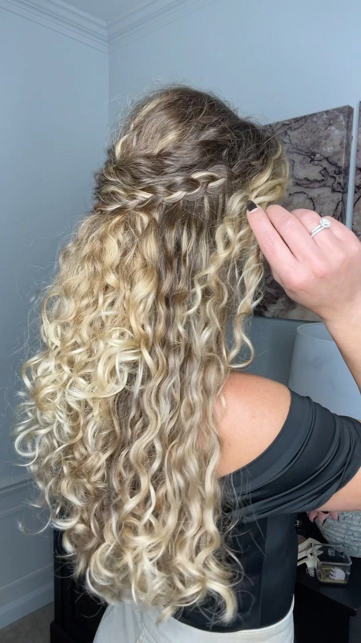 Blonde curly hair styled in a half-up boho braid across the back.
