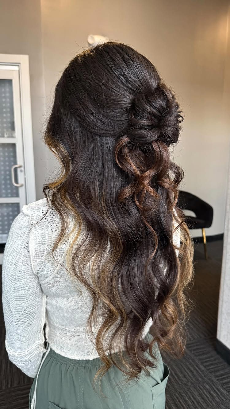 16 Bun Hairstyles for Homecoming: Updos, Braids and More 8 Long wavy brown hair styled in a half up bun with loose curls.