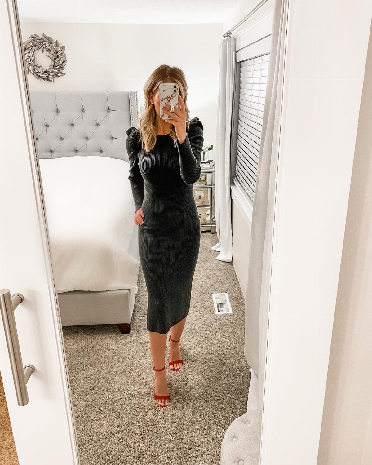 Woman in a dark grey ribbed knit midi dress and red strappy heels.