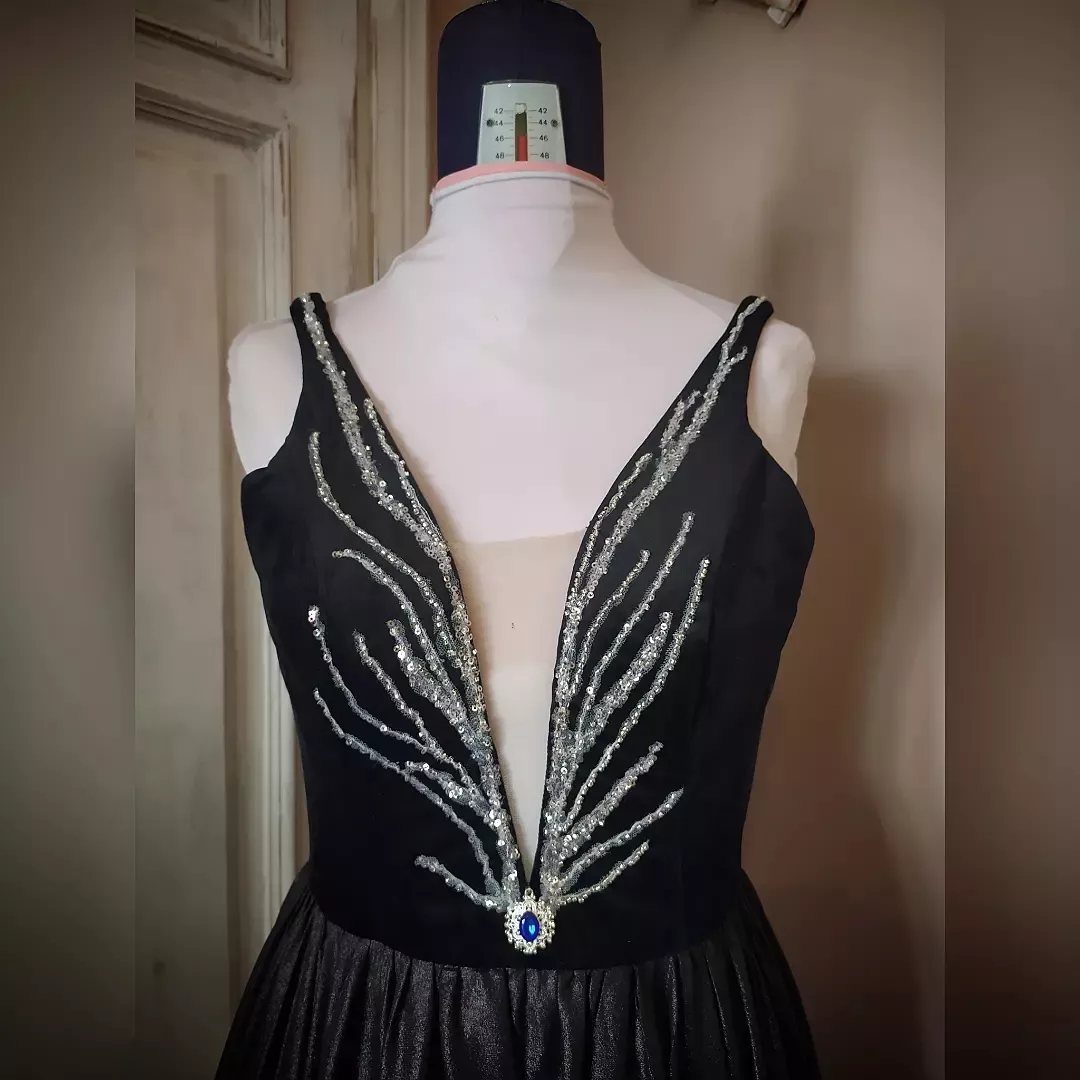 Celaena Sardothien Dresses: 10 Gown Ideas from the Books 7 Black sleeveless gown with silver sequined wing embroidery and a blue gemstone waist.