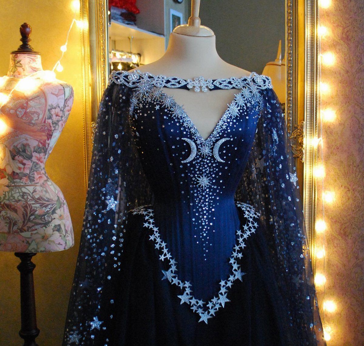 Celaena Sardothien Dresses: 10 Gown Ideas from the Books 4 Dark blue celestial gown with silver moon and star embroidery on a mannequin.