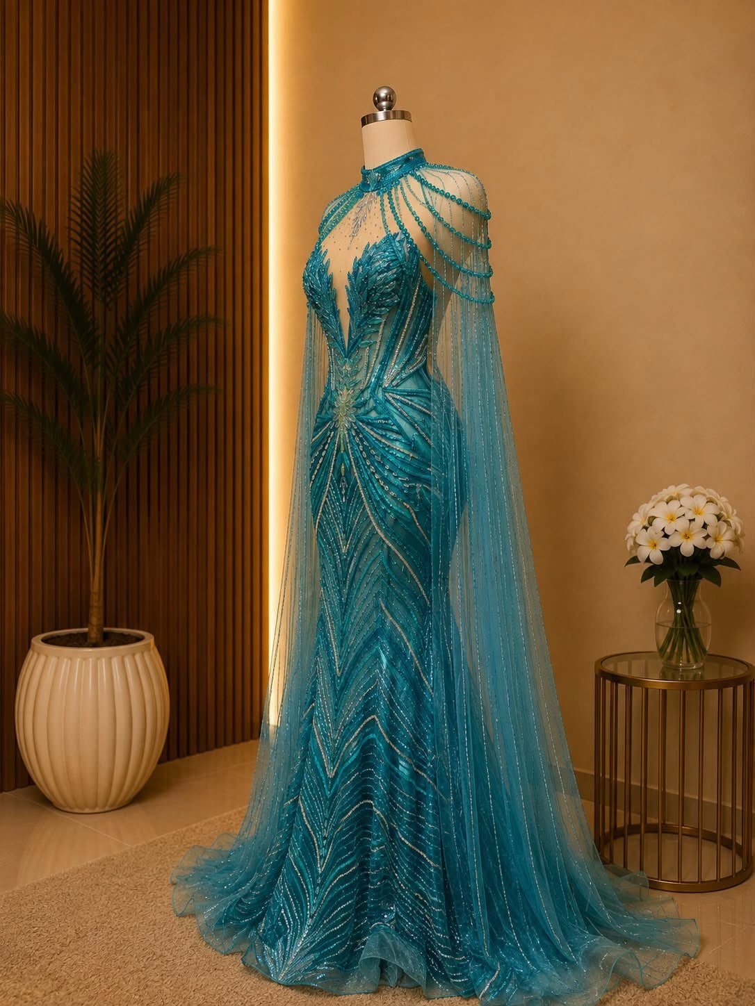 Celaena Sardothien Dresses: 10 Gown Ideas from the Books 3 Teal-blue beaded mermaid gown with a sheer cape on a mannequin.
