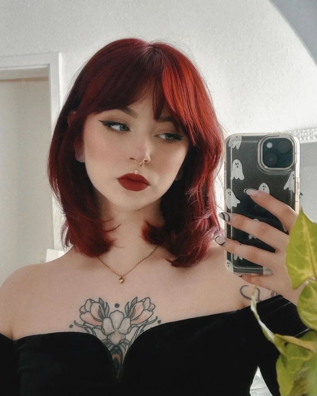 Cherry Red Hair Aesthetic: 7 Ideas for Every Length 4 Woman with cherry red hair and bangs taking a mirror selfie