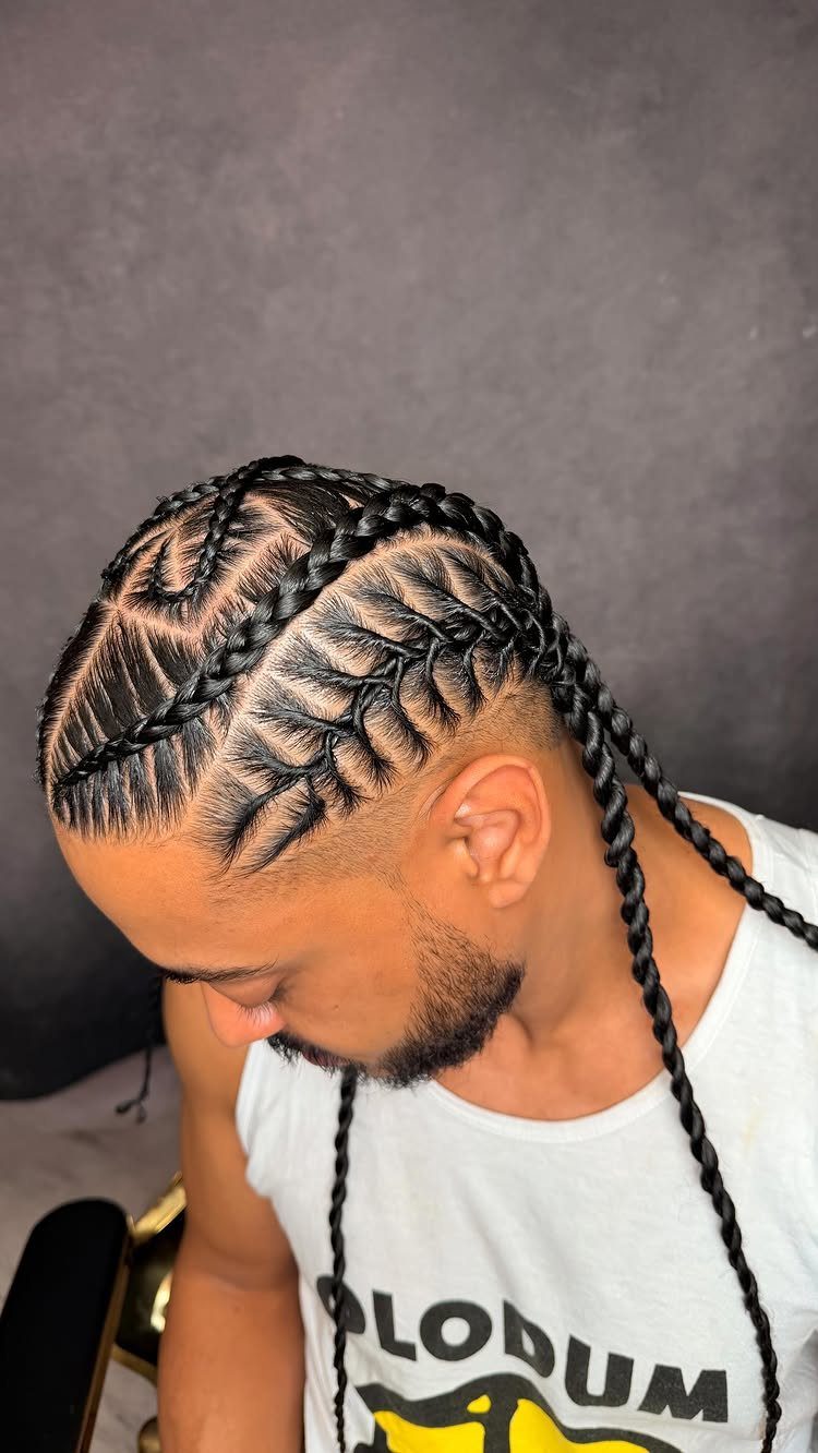 Man with freestyle stitch cornrows and a drop fade haircut in profile view