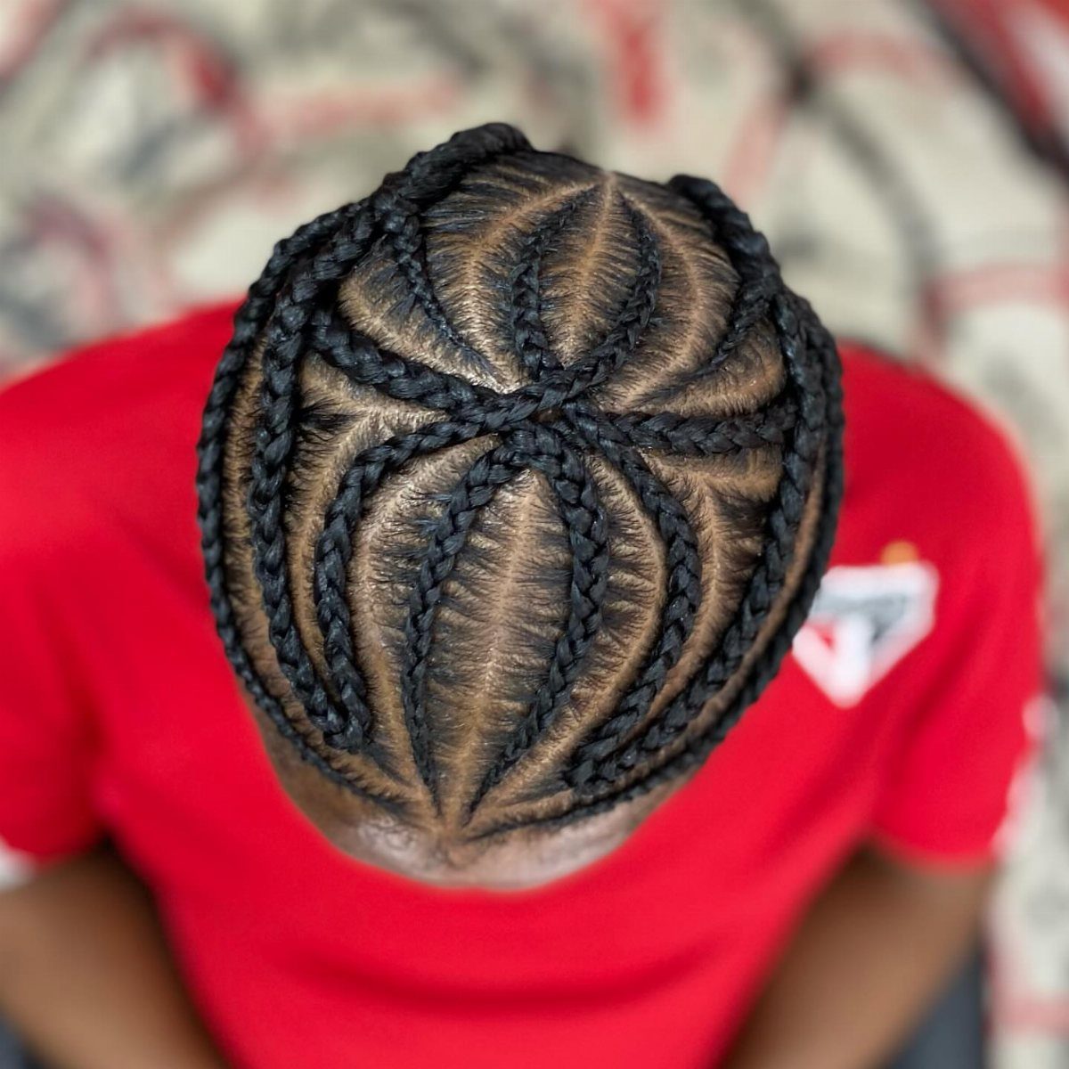 Intricate cornrow braids in a geometric pattern on a man's head
