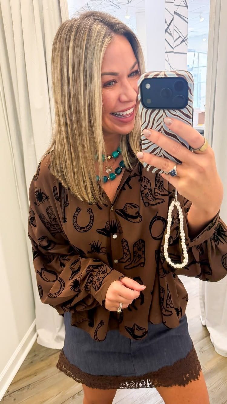 Woman in a brown Western print shirt and denim mini skirt with lace trim.