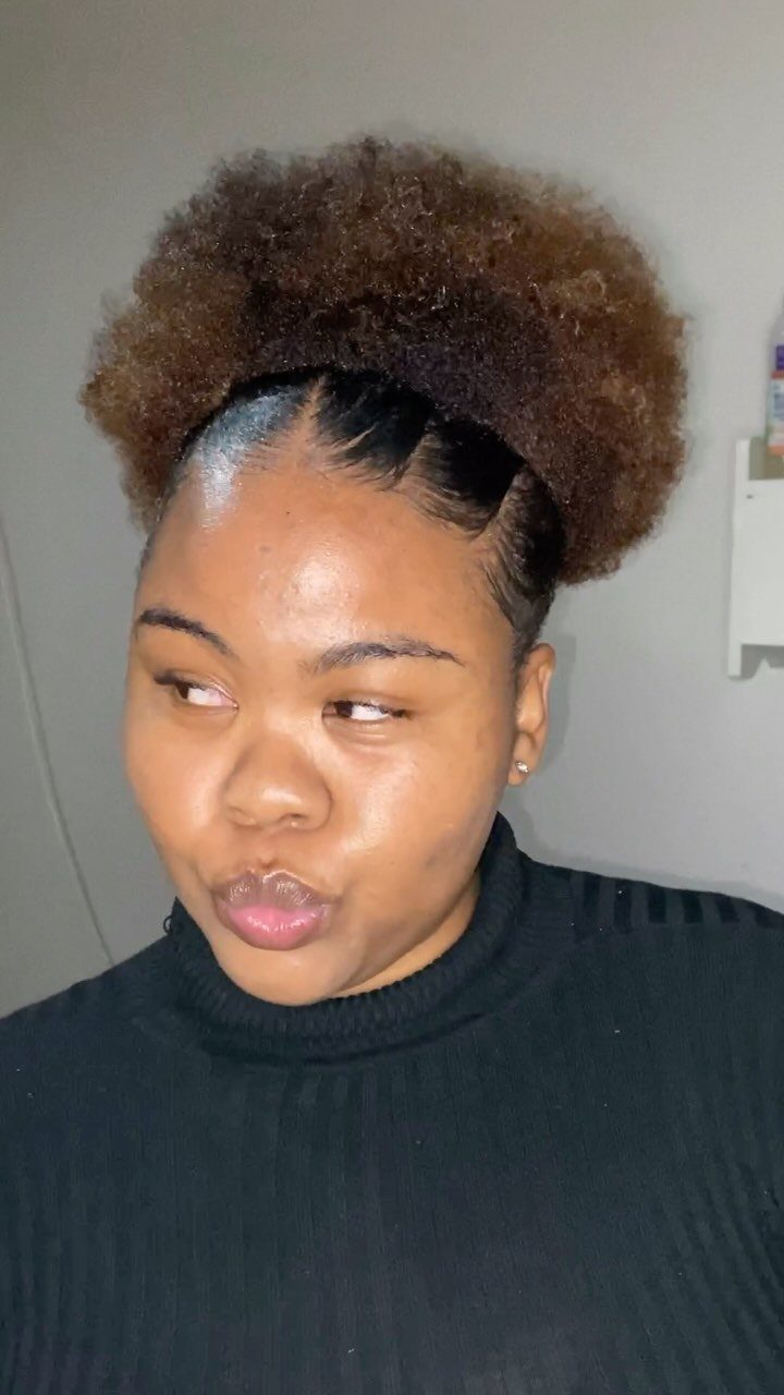 13 Curly Hair Half Up Styles with Braids, Twists and Puffs 1 Woman with brown curly hair styled in a high voluminous half up puff.