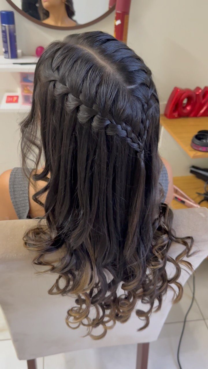 13 Curly Hair Half Up Styles with Braids, Twists and Puffs 8 Long dark brown curly hair styled in a waterfall braid cascading across the back.