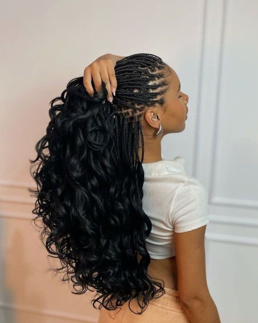 Woman with cornrow braids transitioning into a voluminous high ponytail of black curls.