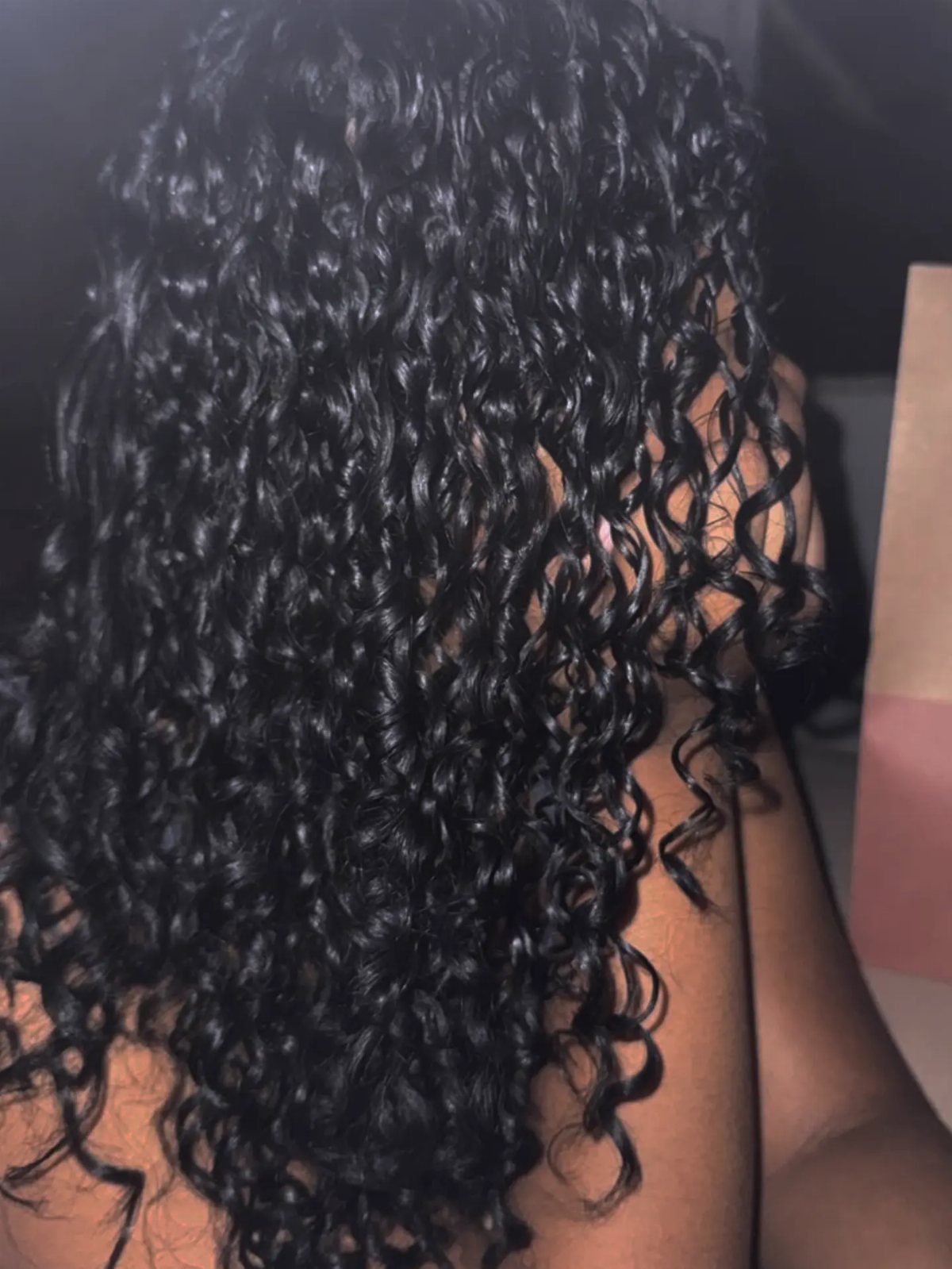 Long, glossy black curly hair with a wet look and defined ringlets.