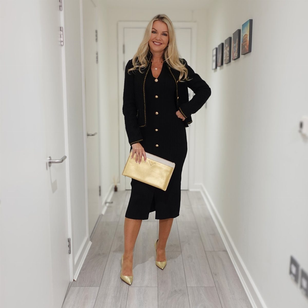 Cute Going Out Shoes to Wear Tonight: 7 Ideas for Women 2 Woman in black suit and gold pointed-toe pumps standing in a white hallway.