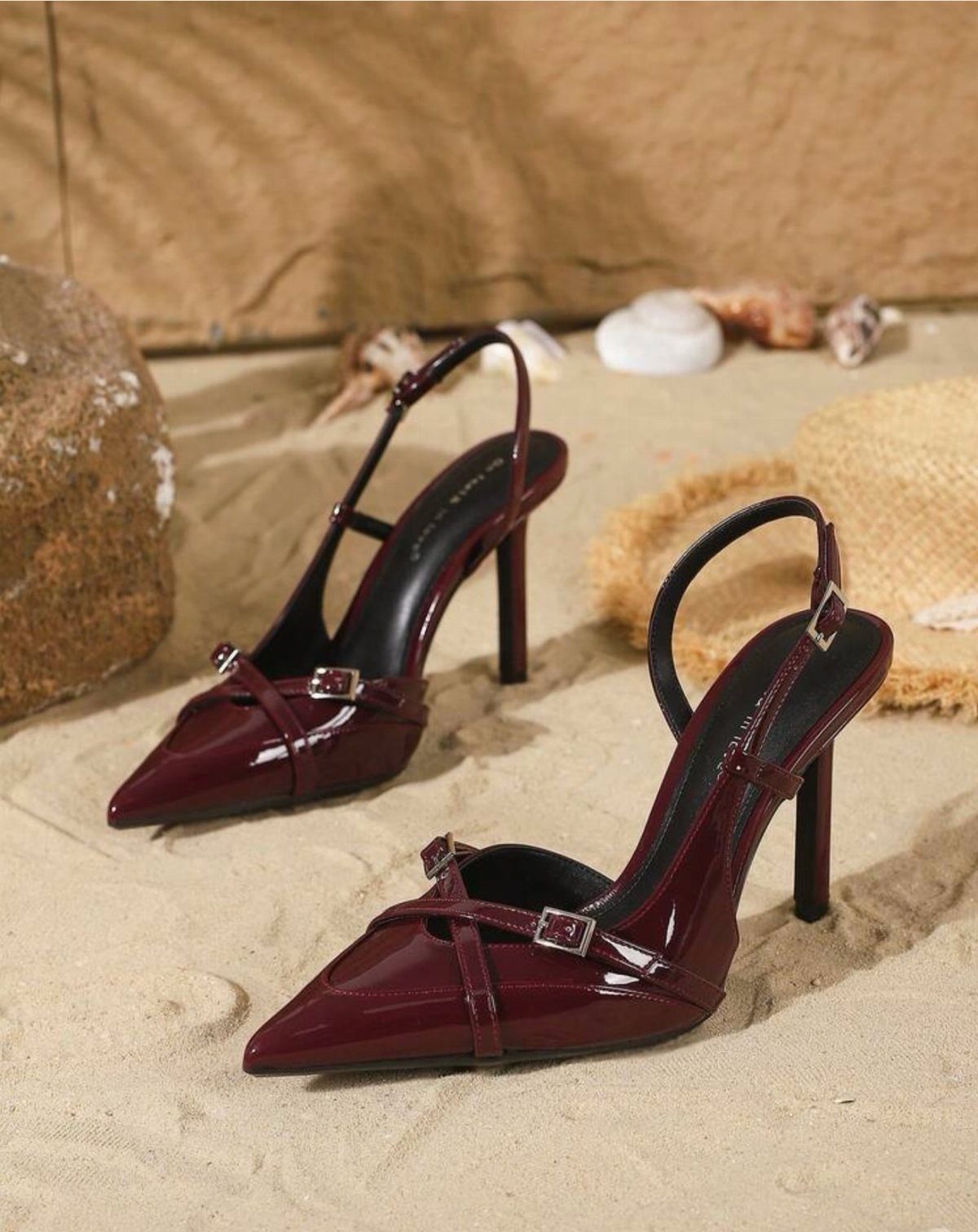 Cute Going Out Shoes to Wear Tonight: 7 Ideas for Women 3 Burgundy glossy pointed-toe stiletto heels with ankle straps resting on sandy beach ground.