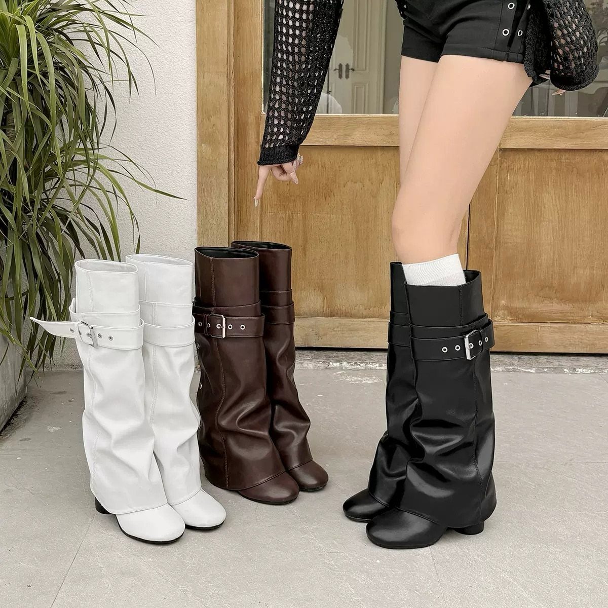 Cute Long Boots: 10 Ideas, From Combat to Over the Knee 8 Black, white, and brown slouchy long boots with buckle straps on concrete.