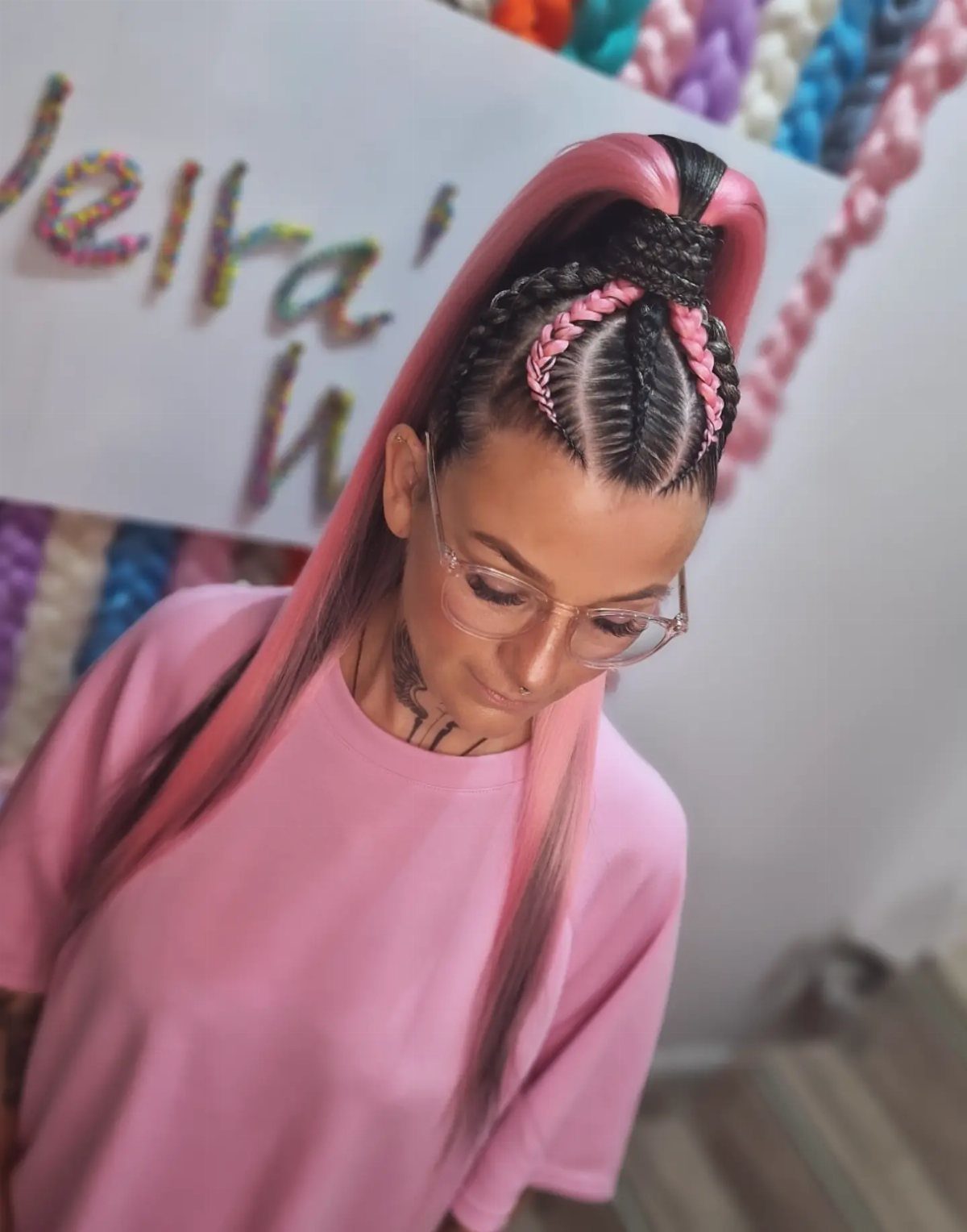 18 Cute Ponytail Hairstyles for Every Mood and Length 1 Woman with pink hair featuring cornrow braids tied into a high ponytail.