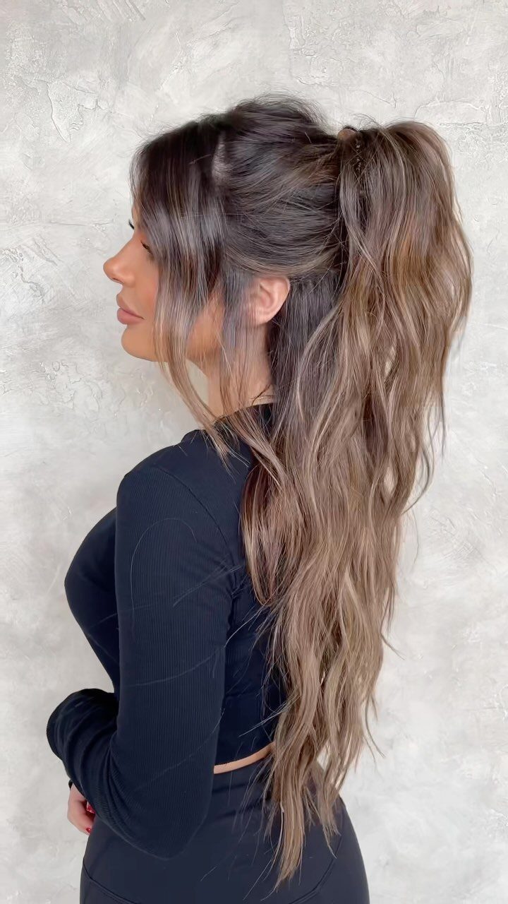 18 Cute Ponytail Hairstyles for Every Mood and Length 12 Woman with long brown hair styled in a high, voluminous messy ponytail.