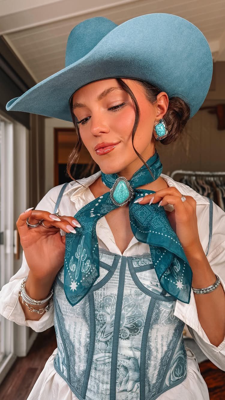 Cute Western Outfits for Women: 13 Ideas to Wear Now 3 Woman wearing a blue cowboy hat, turquoise bandana, and matching western jewelry accessories.