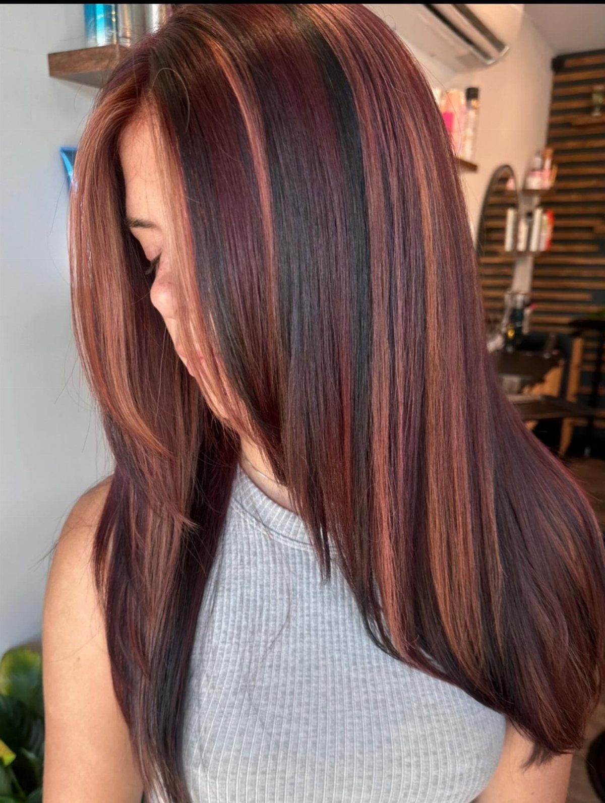 5 Dark Crimson Hair Ideas, From Merlot to Copper Tones 4 Woman with long straight hair dyed in copper and red highlights.