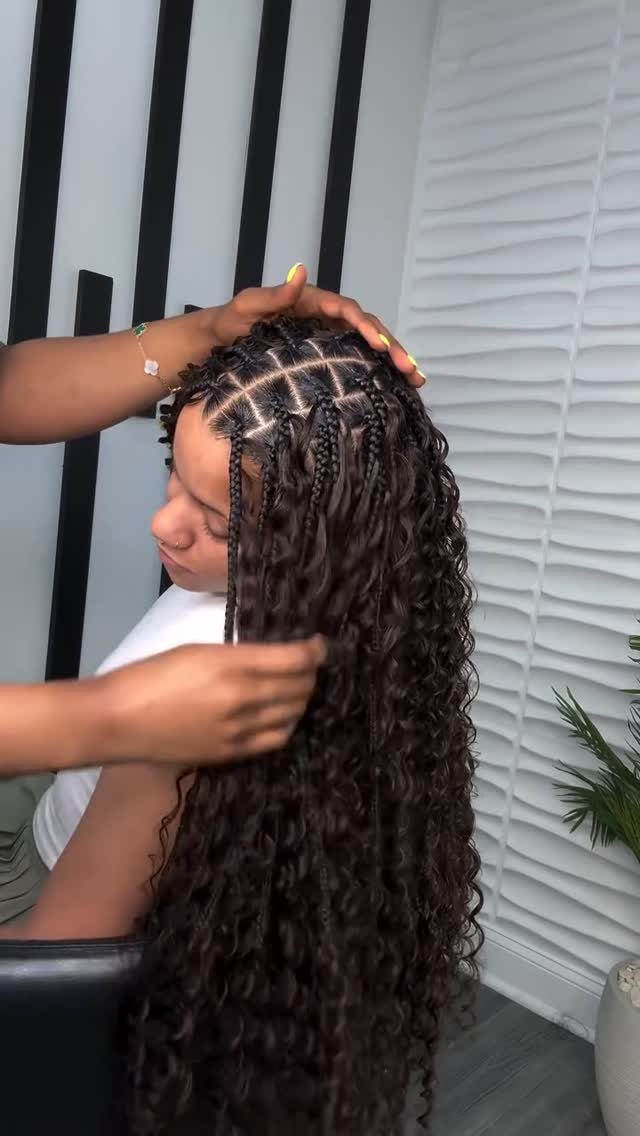 Long dark curly gypsy braids being styled on a person in a salon.
