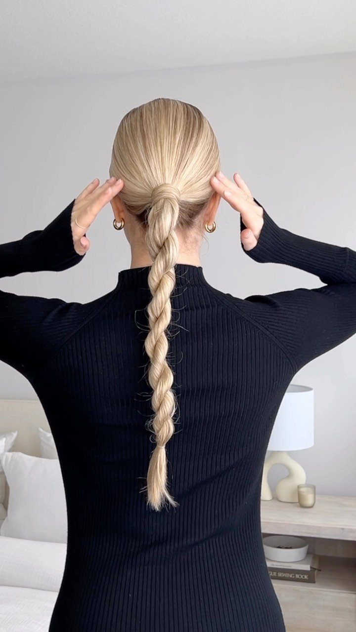 Blonde hair styled in a long rope braid ponytail on a woman.