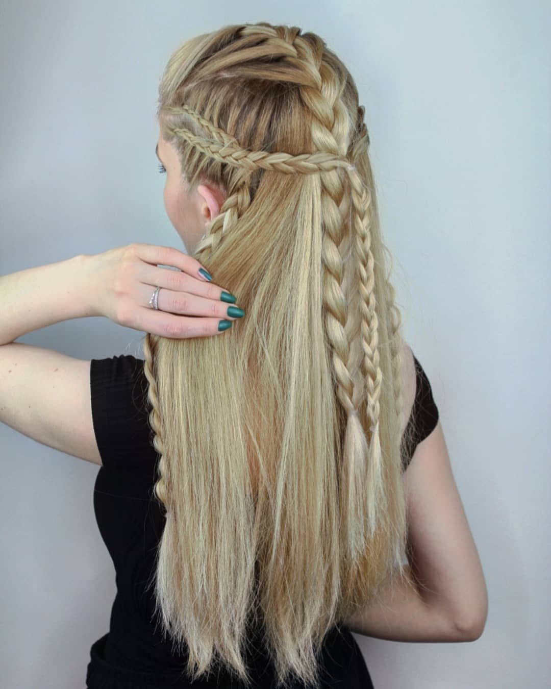 Blonde woman with intricate Viking style braids and long flowing hair from behind.