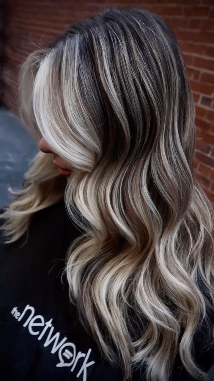 14 Different Color Hair Ideas for Every Skin Tone 4 Woman with long wavy hair featuring blonde balayage highlights and dark roots.