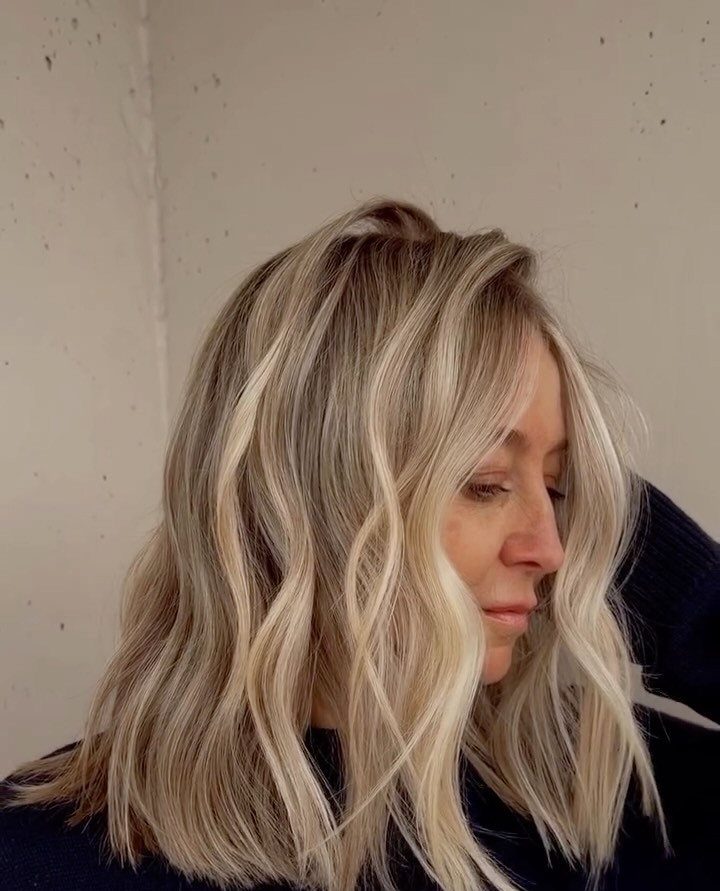14 Different Color Hair Ideas for Every Skin Tone 10 Woman with wavy butter blonde hair and light brown lowlights in profile