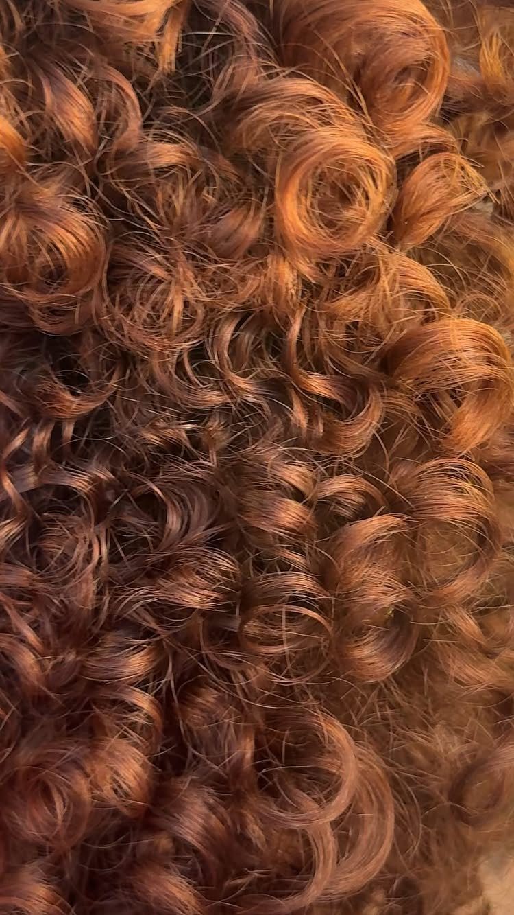 14 Different Color Hair Ideas for Every Skin Tone 2 Curly hair in a vibrant cinnamon copper red shade shown in close-up.