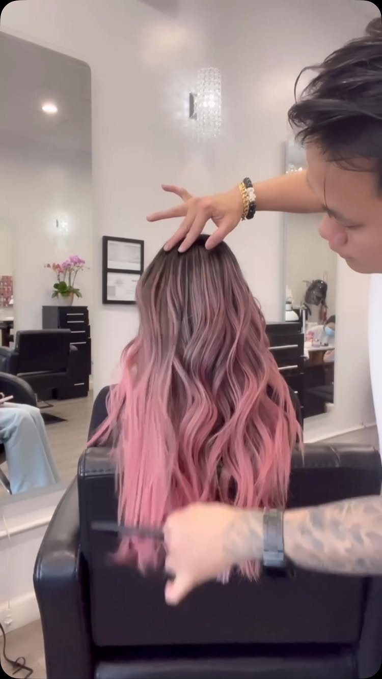 14 Different Color Hair Ideas for Every Skin Tone 6 Woman with long wavy pastel pink ombre hair being styled in a salon