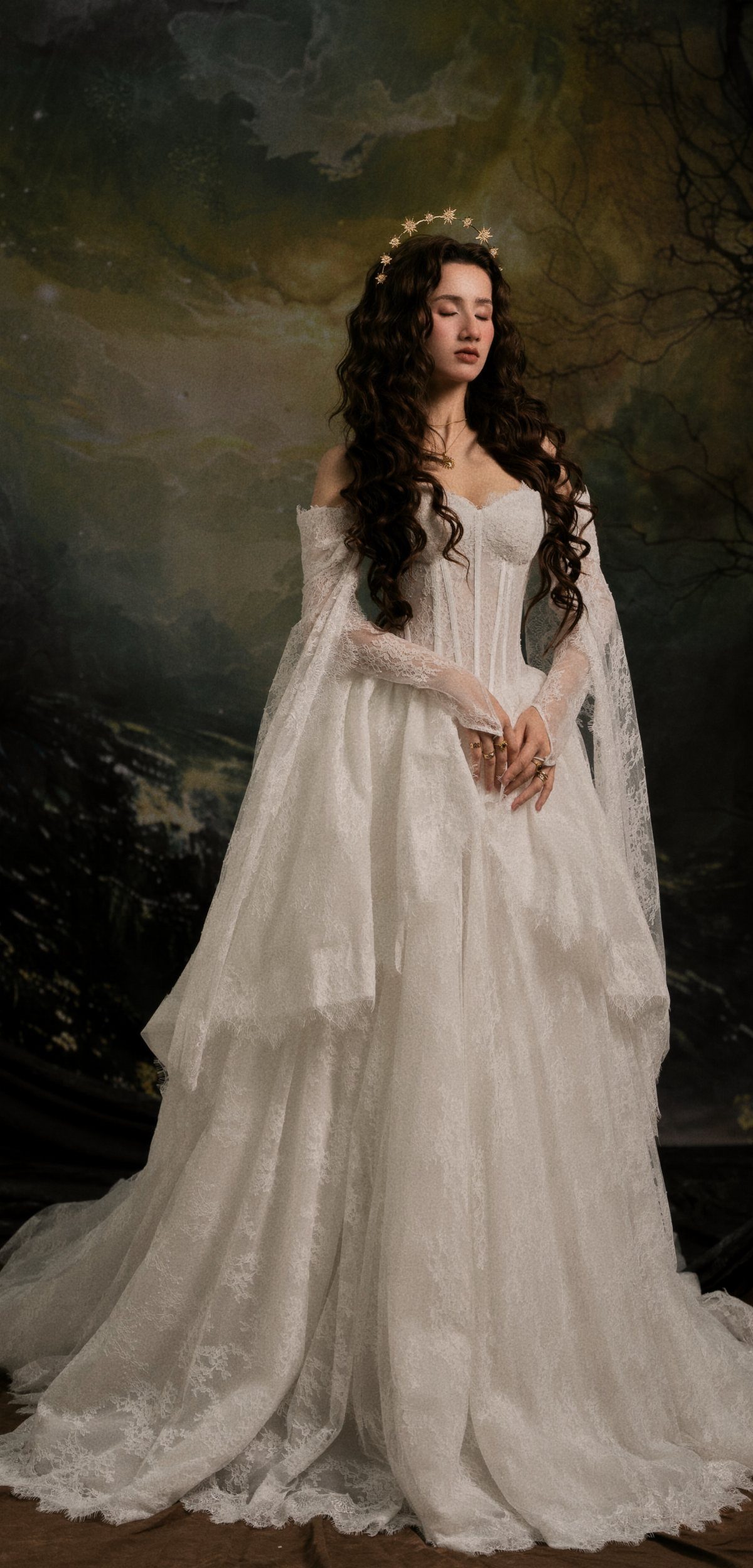 Woman in a white lace heirloom fairy bridal gown with a gold crown