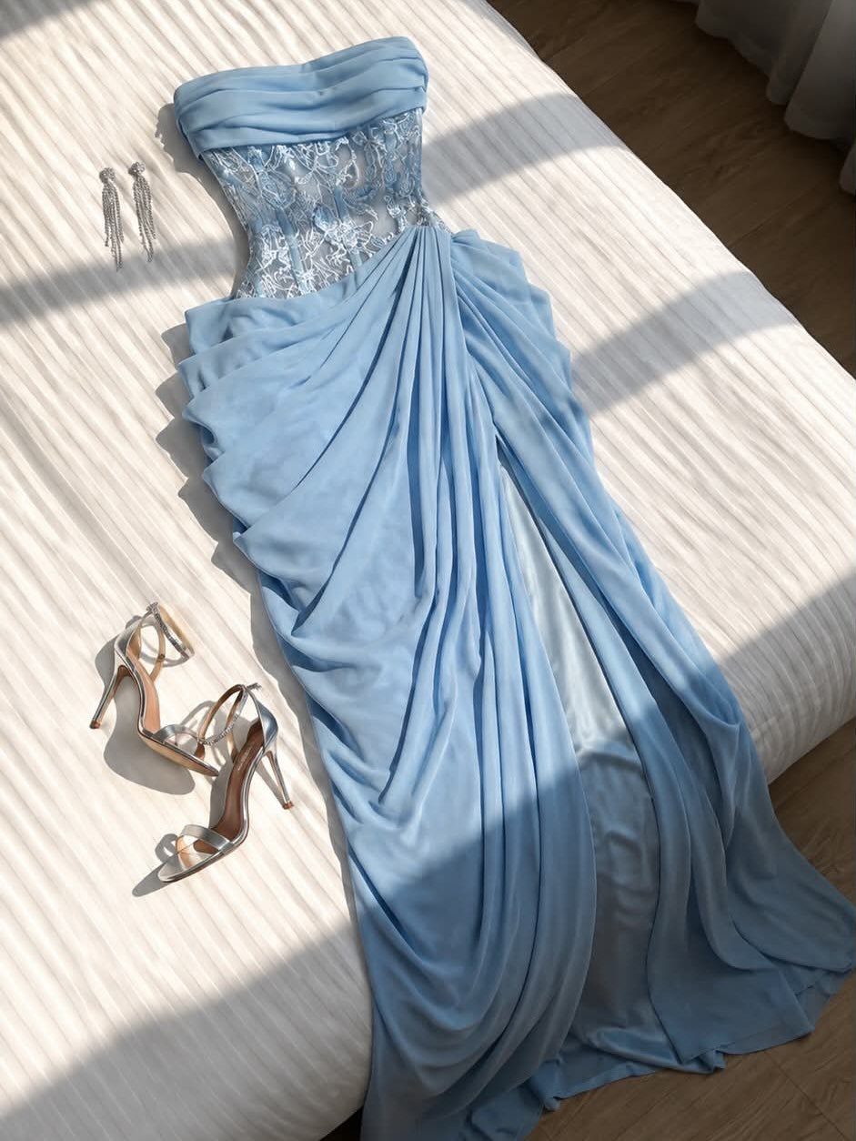 Light blue gown with lace bodice and draped skirt on a white bed.