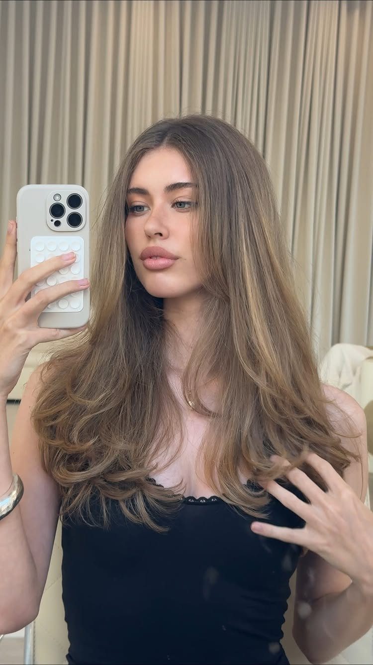 Fall Hairstyles and Color: 16 Ideas, Caramel to Espresso 14 Woman with long wavy honey blonde and light brown hair taking a selfie