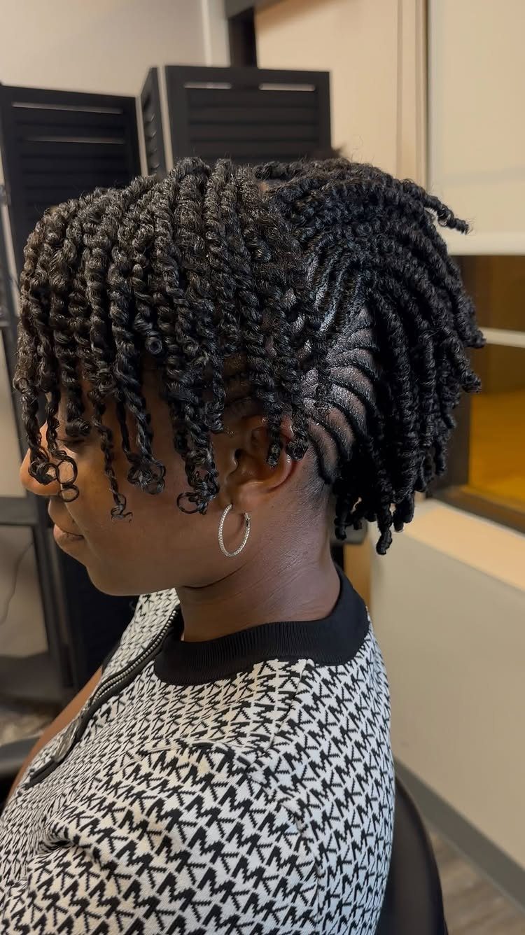 Woman with black hair in a flat twist mohawk style with loose ends.