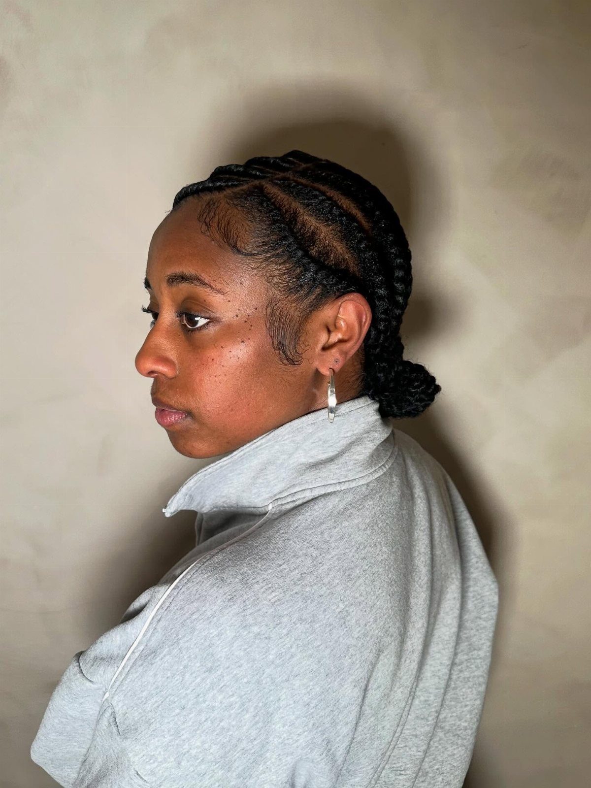 Woman with flat twist hairstyle gathered into a low bun in side profile