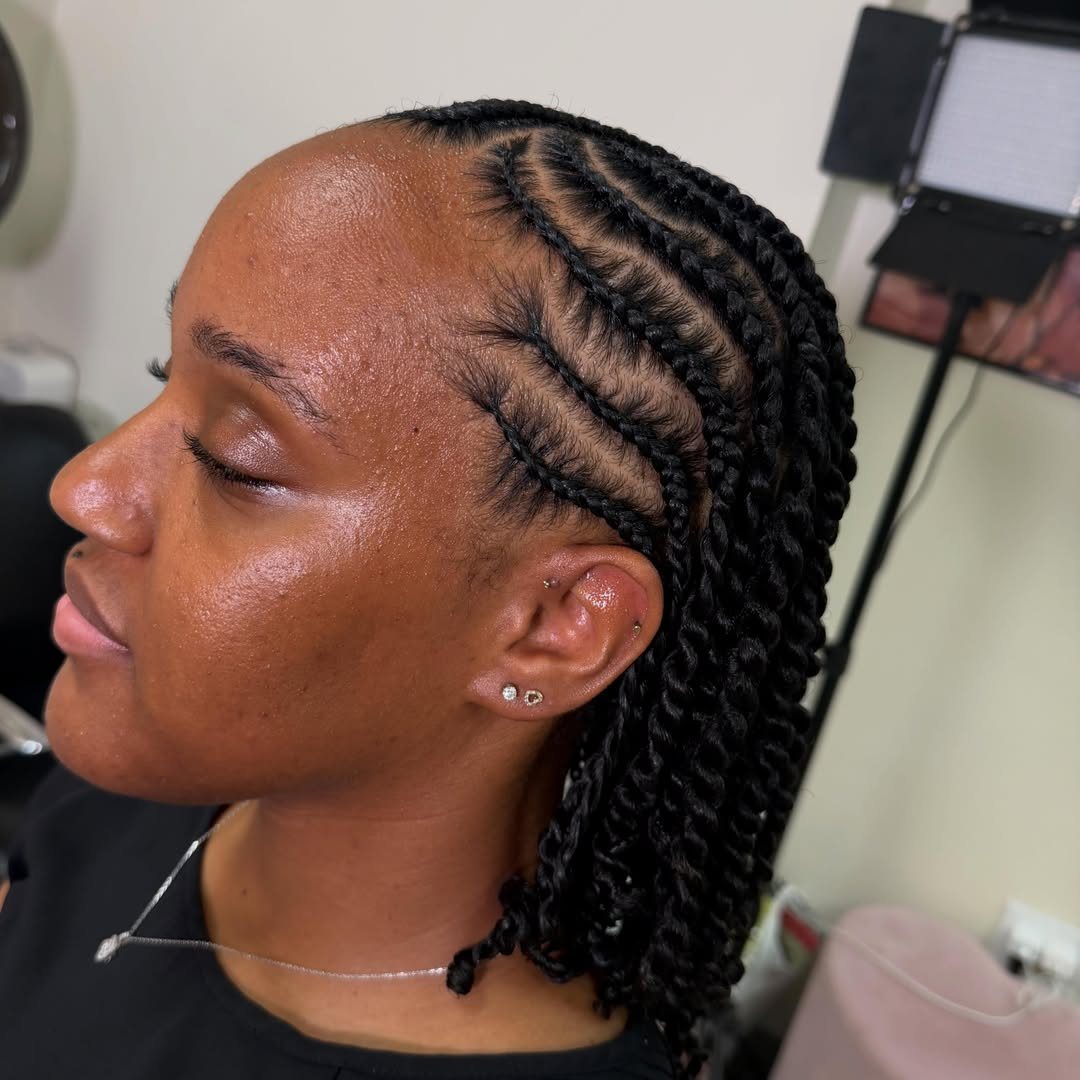 Woman with black hair styled in flat twists along the scalp and hanging twists.
