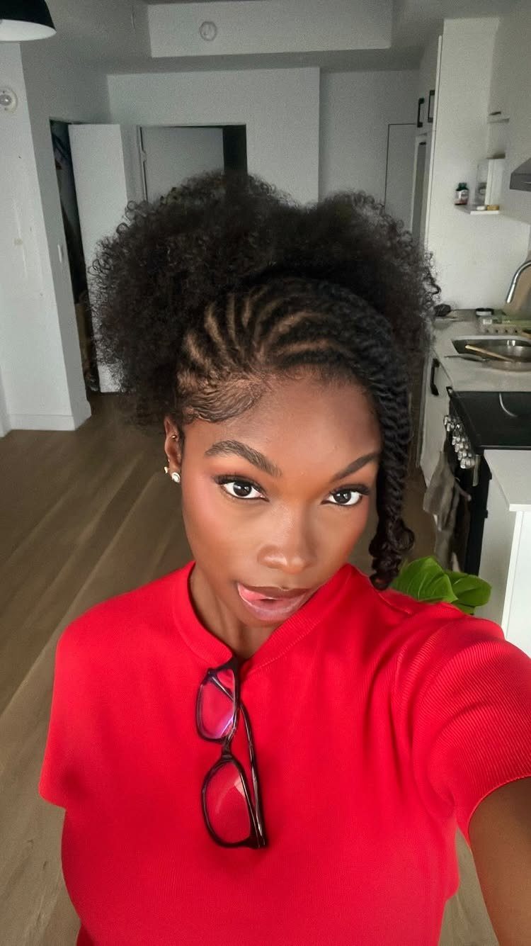 Woman with flat twist hairstyle and a large curly afro puff on top