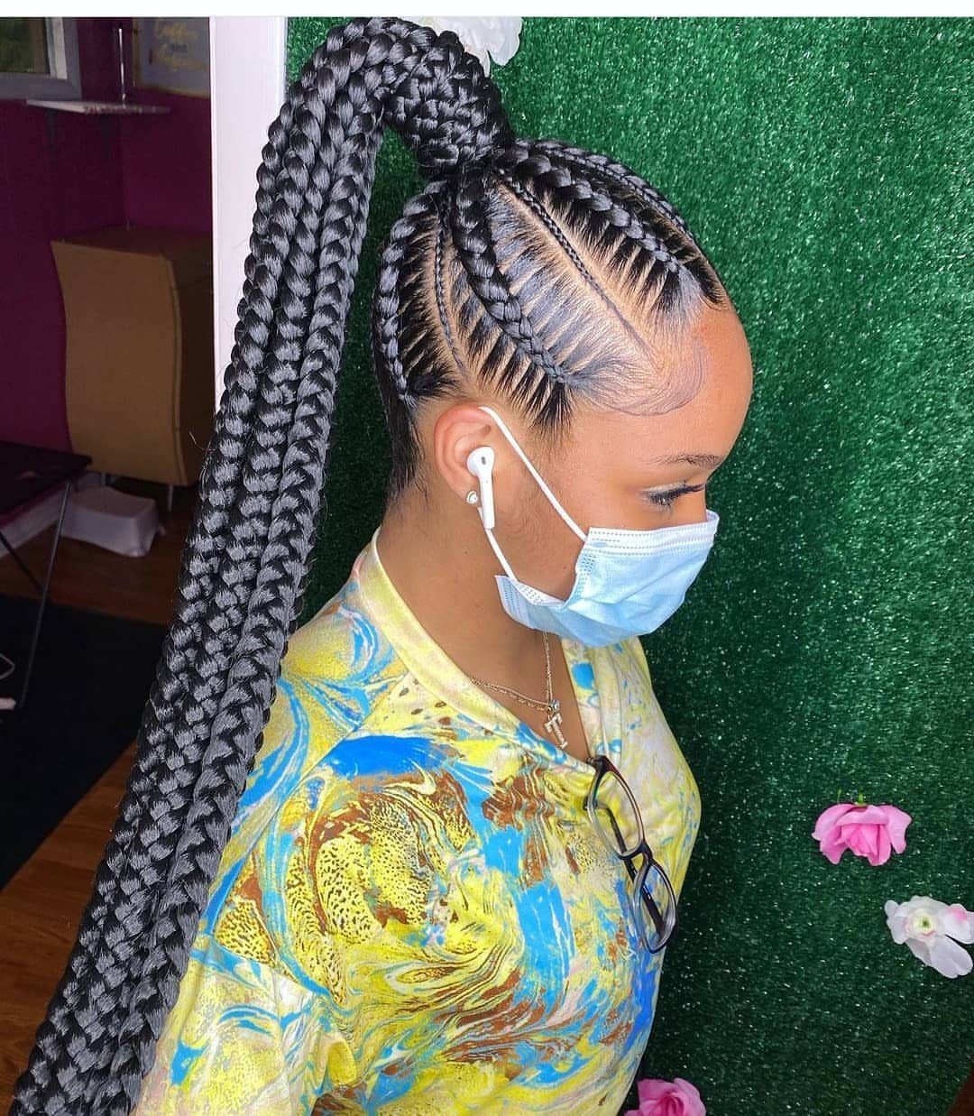 Woman with black cornrows styled into a high, long braided ponytail.