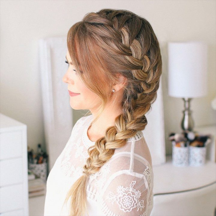 Woman with light brown hair styled in a thick, elegant French braid.
