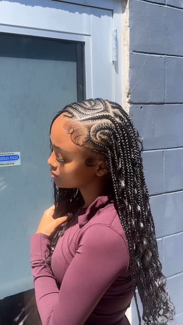 Woman with intricate Fulani braids featuring cornrow patterns and long hanging braids.