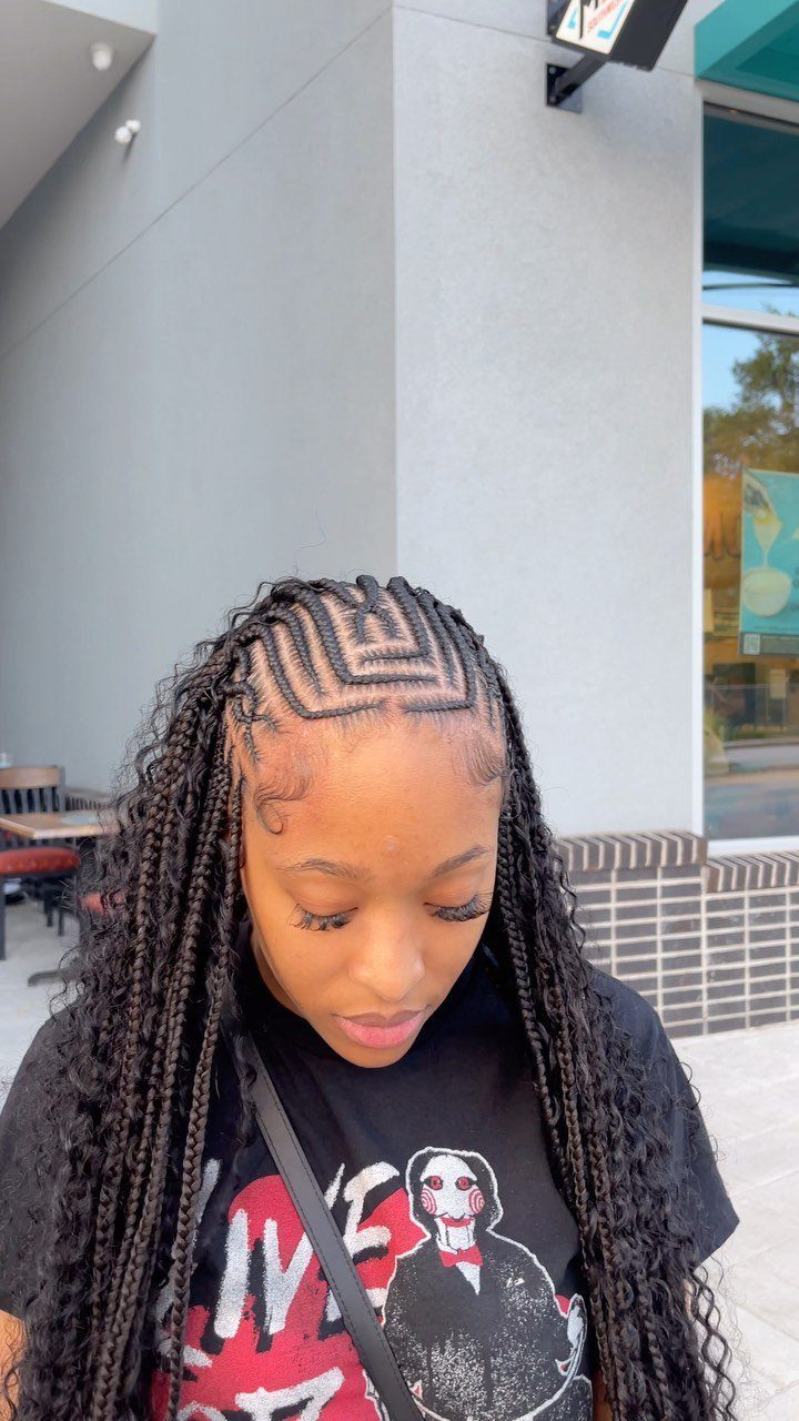 Woman with long black knotless braids and geometric cornrow patterns on her scalp.