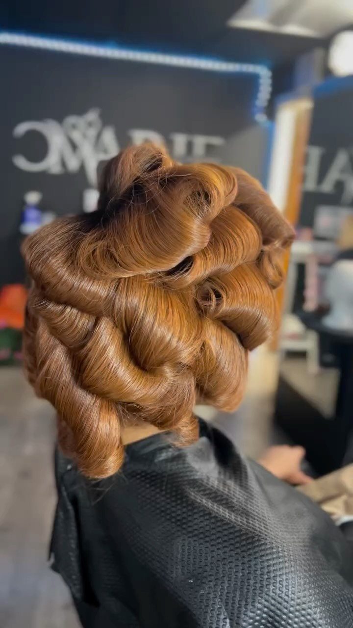 Copper-brown hair styled in glossy, structured curls at a professional hair salon.