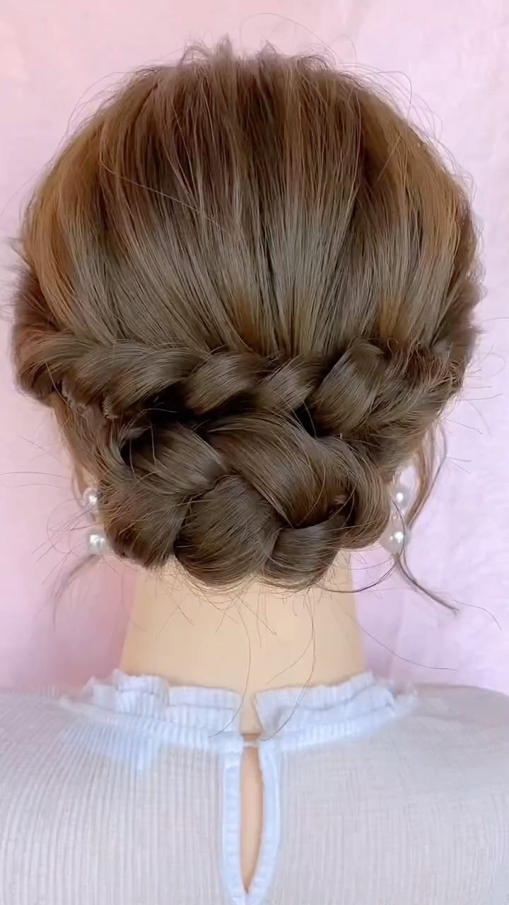 Light brown hair styled in a low braided chignon updo on a mannequin.