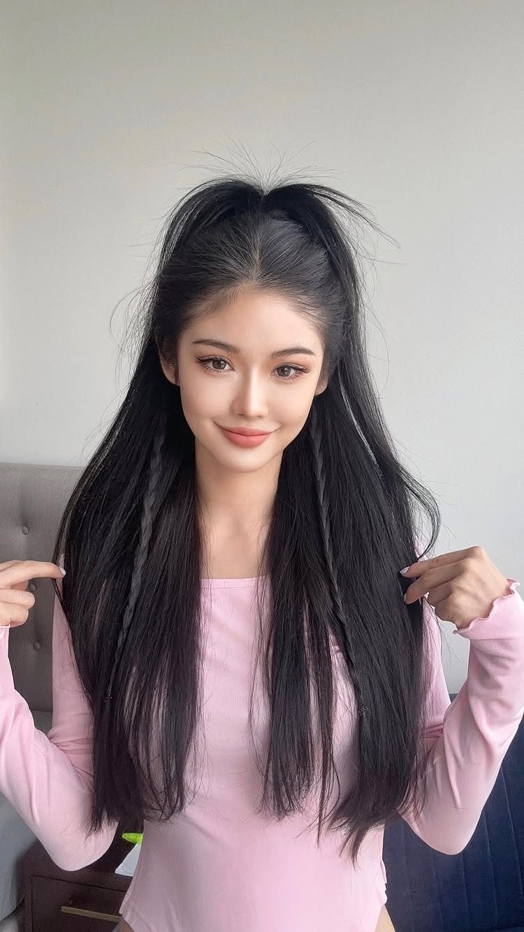 Woman with long black hair styled in a half-up, half-down high ponytail.