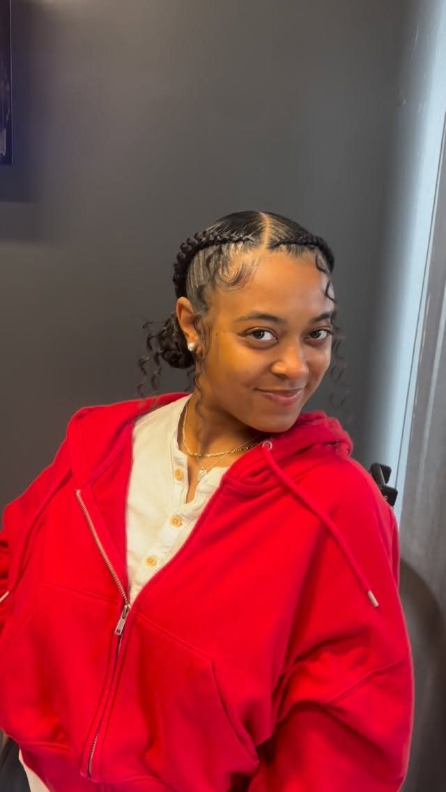 Woman with dark curly hair styled in cornrow braids and a low bun.